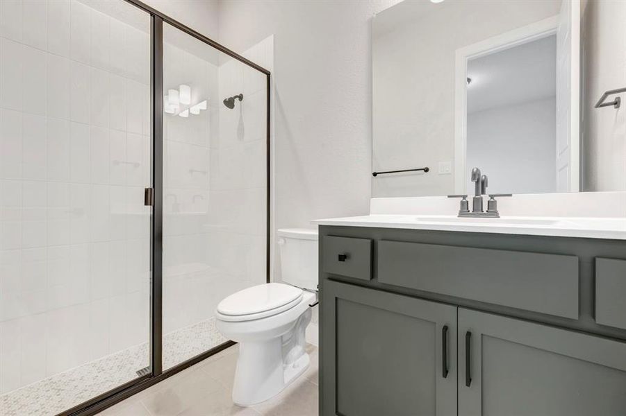 Bathroom featuring a shower stall and vanity