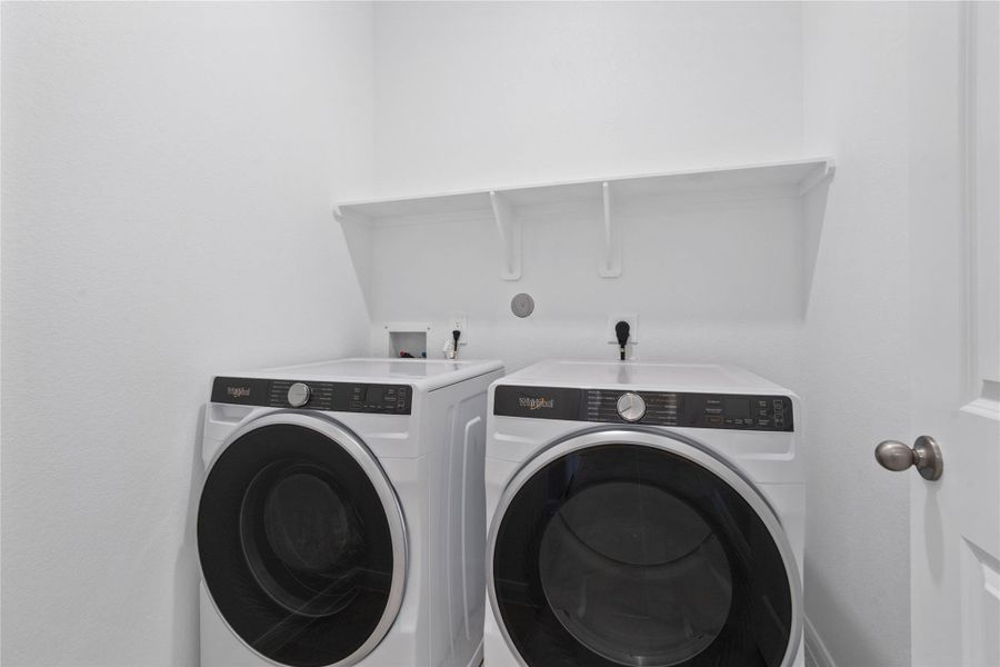 This dedicated laundry room comes equipped with a washer and dryer set, ready for immediate use.