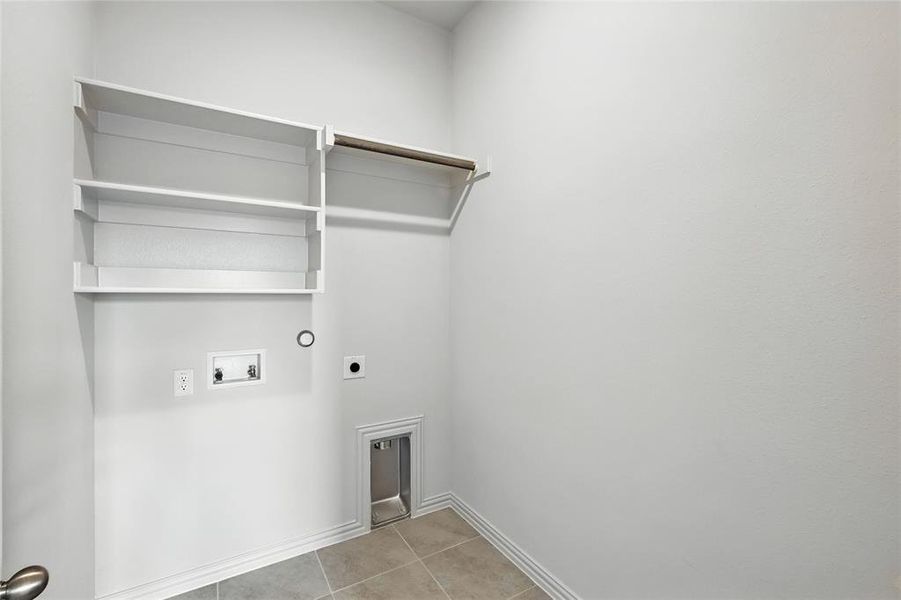 Laundry area with hookup for an electric dryer, light tile patterned floors, and washer hookup Laundry area with hookup for an electric dryer, light tile patterned floors, and washer hookup