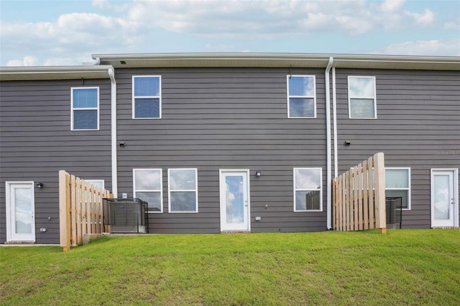 Exterior details and patio area of a home in The Enclave Townhomes, Hampton (Image 4).