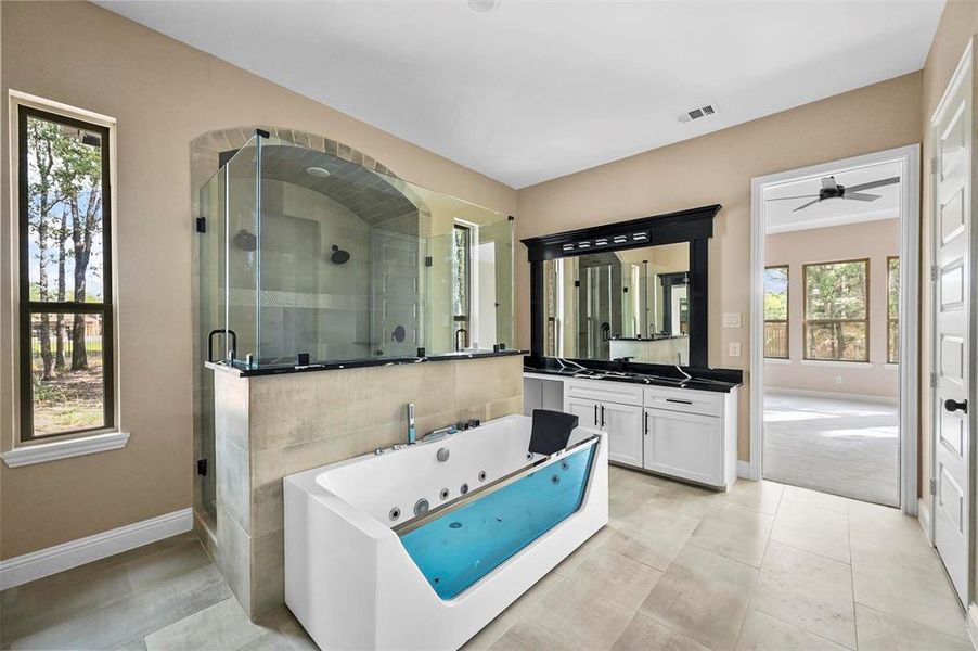 Bathroom with a healthy amount of sunlight, tile patterned floors, vanity, and ceiling fan