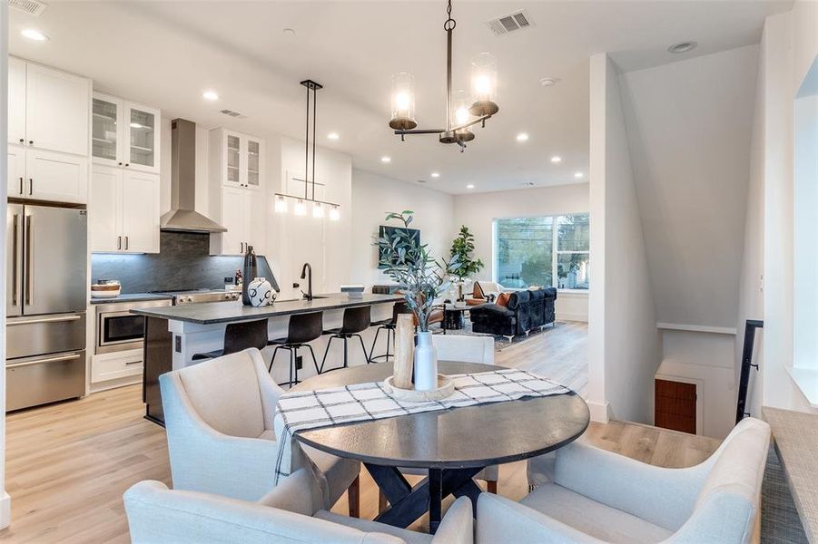 Dining space featuring a chandelier, light hardwood / wood-style floors, and sink