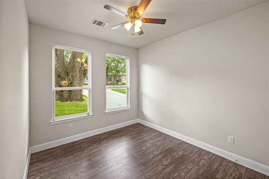 Empty room featuring dark hardwood / wood-style floors and ceiling fan