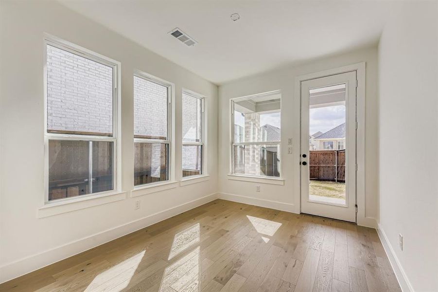 Unfurnished sunroom with hardwood / wood-style floors and baseboards Unfurnished sunroom with hardwood / wood-style floors and baseboards