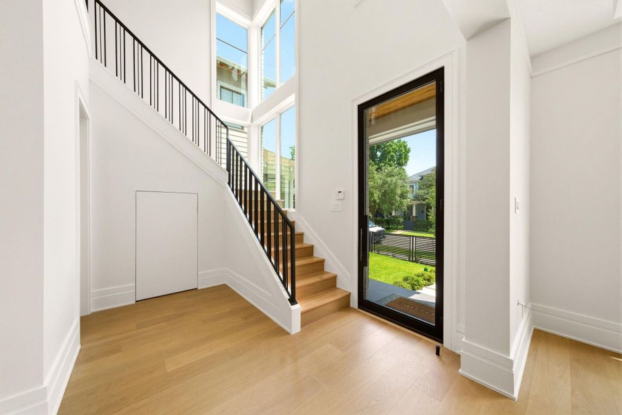 Impressive staircase leads you upstairs with bold iron detailing. Dramatic windows overlooking the front yard. Impressive staircase leads you upstairs with bold iron detailing. Dramatic windows overlooking the front yard.