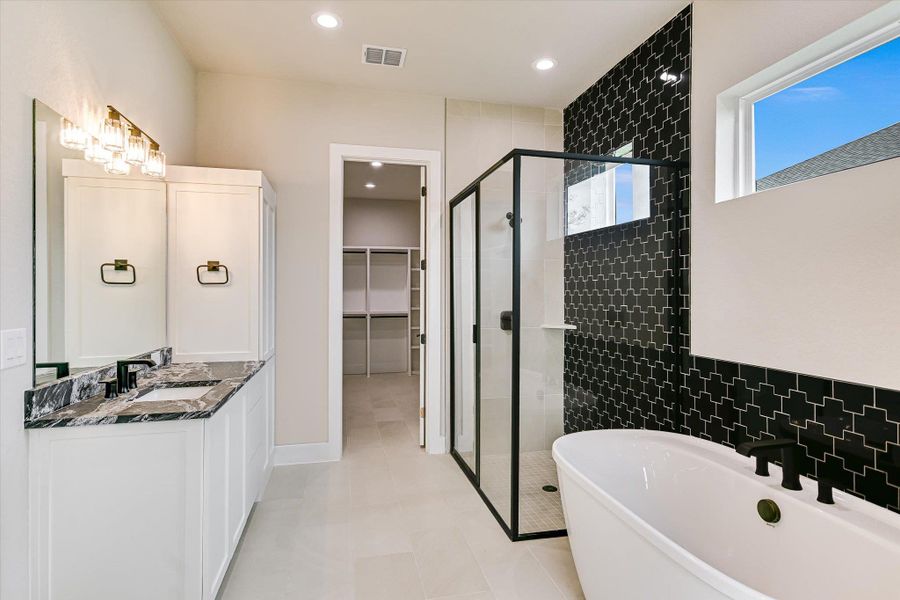 Full bathroom featuring a shower stall, a freestanding bath, vanity, recessed lighting, and a spacious closet