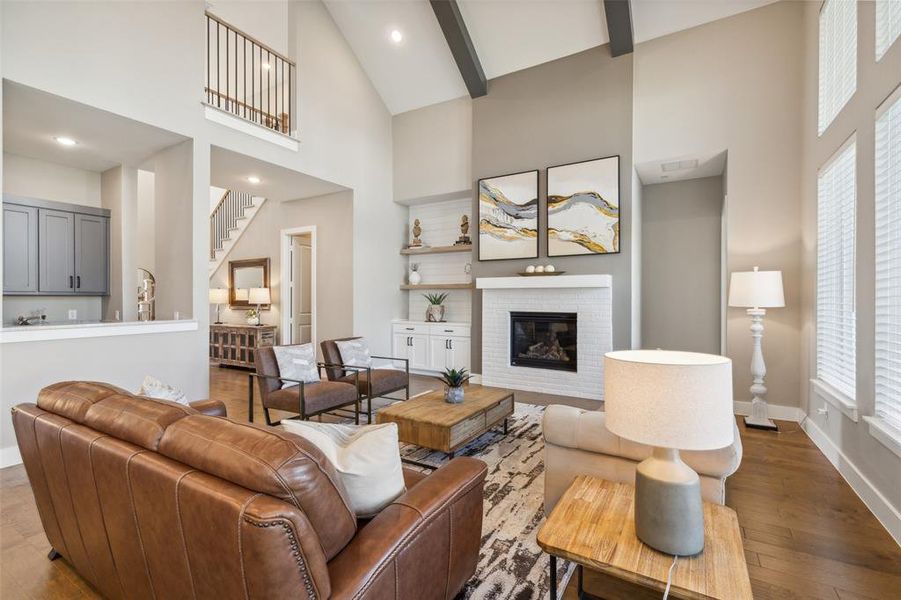 Living room featuring beamed ceiling, high vaulted ceiling, wood-type flooring, and a fireplace