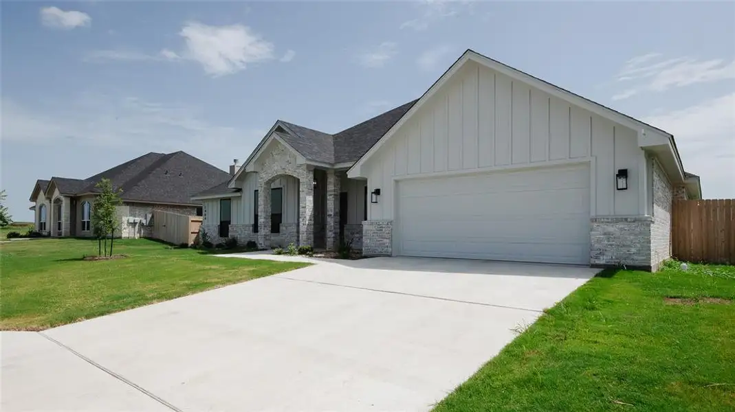 View of front facade featuring board and batten siding, a garage, concrete driveway, and a shingled roof View of front facade featuring board and batten siding, a garage, concrete driveway, and a shingled roof
