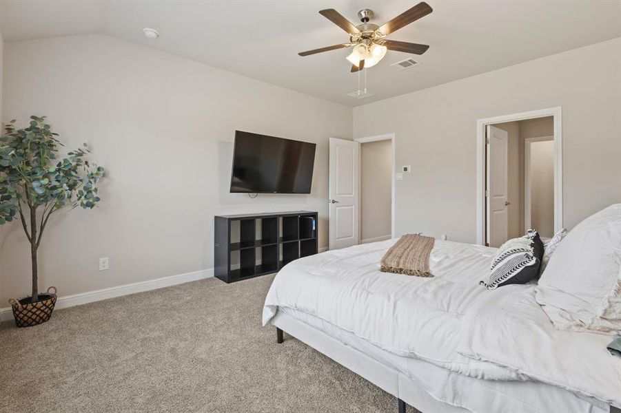 Spacious room featuring vaulted ceilings, light gray wall paint, and gray carpet flooring Spacious room featuring vaulted ceilings, light gray wall paint, and gray carpet flooring