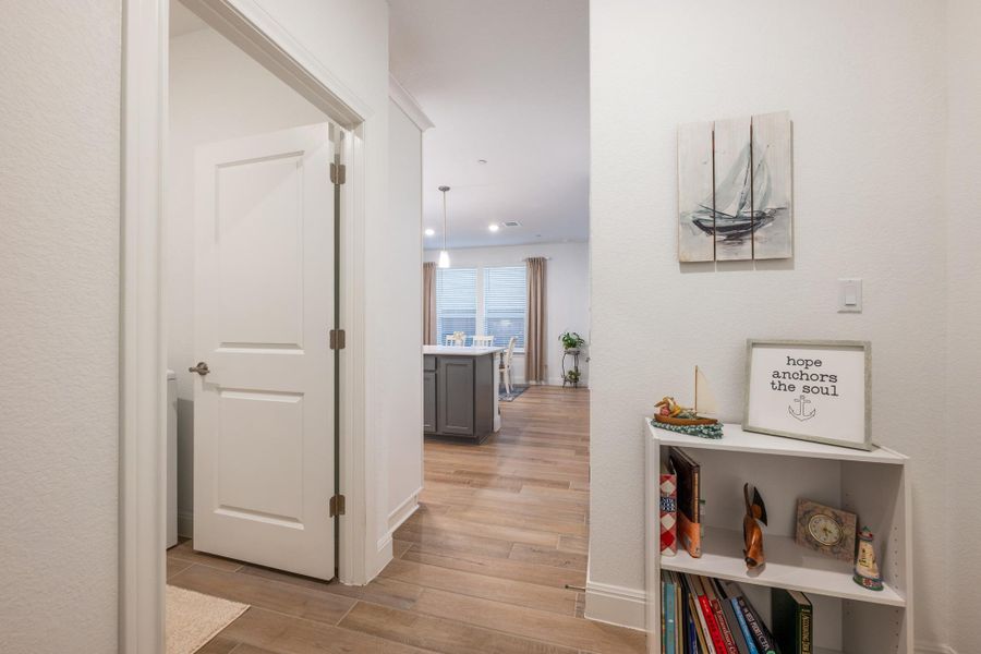 An inviting hallway with plank flooring flows into a well-lit living area. An inviting hallway with plank flooring flows into a well-lit living area.