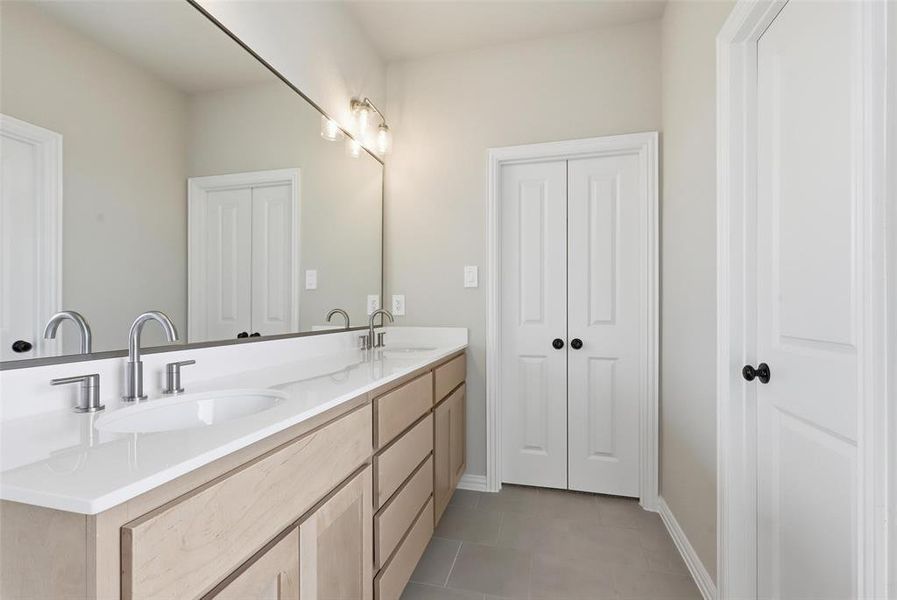 Bathroom with double vanity and light tile patterned floors Bathroom with double vanity and light tile patterned floors