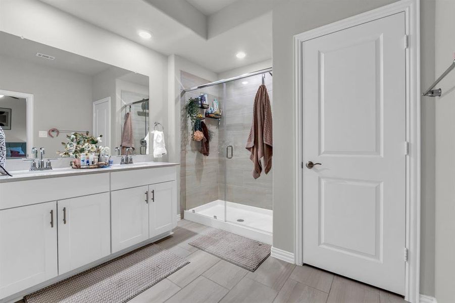 Bathroom with vanity and a shower with door