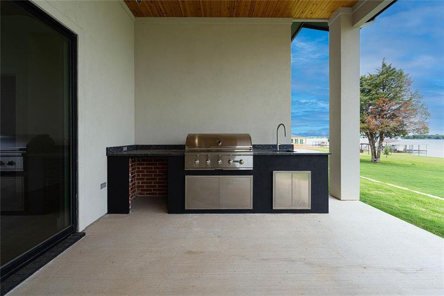 View of First Floor patio featuring an outdoor kitchen, area for grilling, a sink, and a water view View of First Floor patio featuring an outdoor kitchen, area for grilling, a sink, and a water view