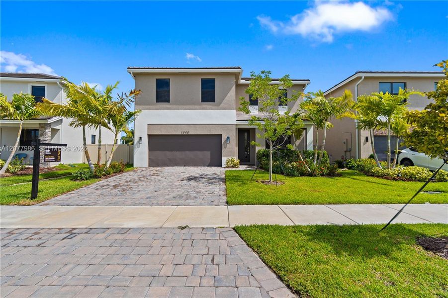Front exterior of a new home in Parker Pointe, Homestead, FL, highlighting curb appeal (Image 2). Front exterior of a new home in Parker Pointe, Homestead, FL, highlighting curb appeal (Image 2).