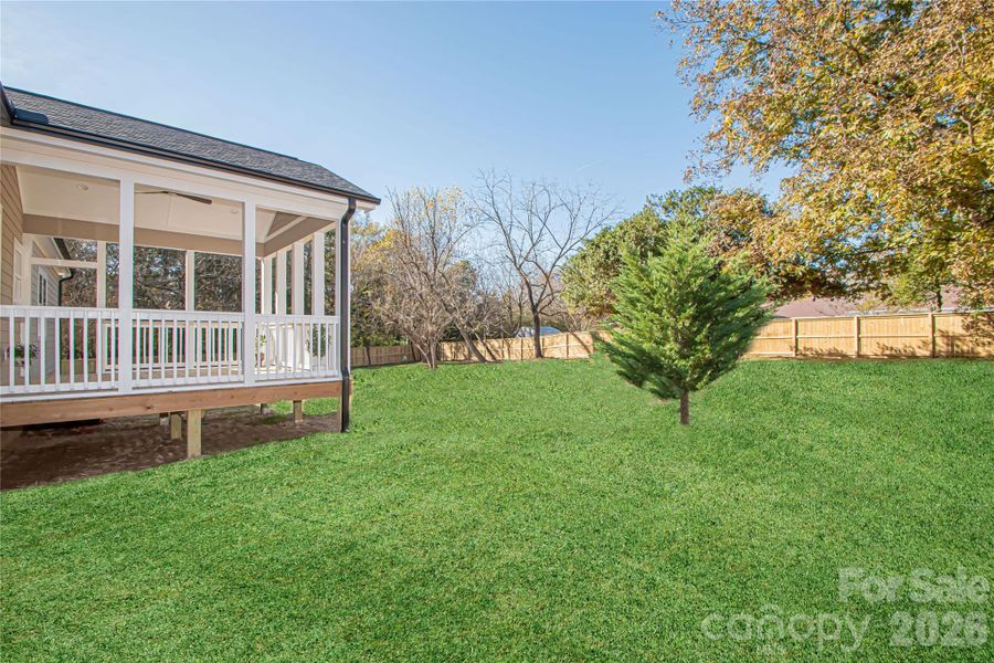 Expansive, flat, fenced backyard provides a serene and peaceful outdoor space. Grass color has been digitally enhanced to reflect its lush spring and summer appearance.
