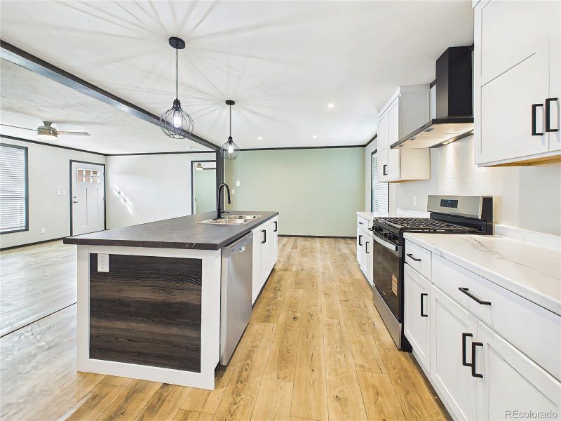 Kitchen – Open-concept kitchen featuring a large island with seating, modern cabinetry, and sleek countertops, seamlessly connecting to the main living area.