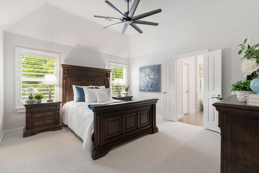 Primary bedroom offers cove ceilings and windows with shutters -