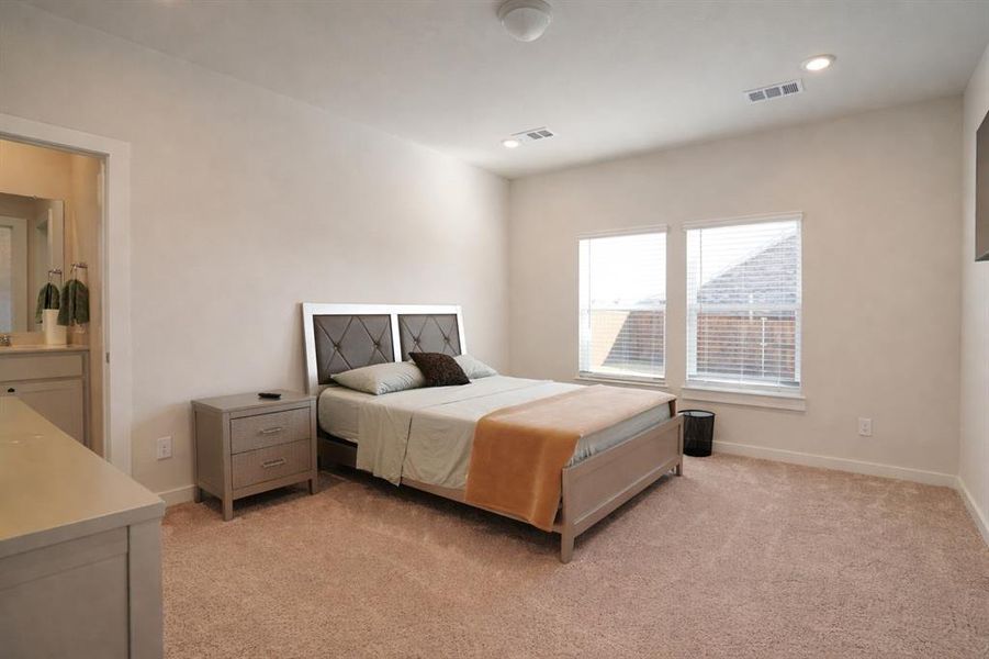 Bedroom with light colored carpet and recessed lighting