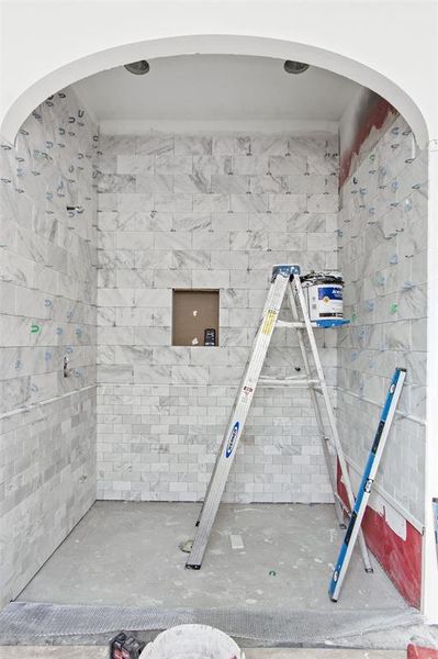 Full bath featuring concrete flooring and a tile shower