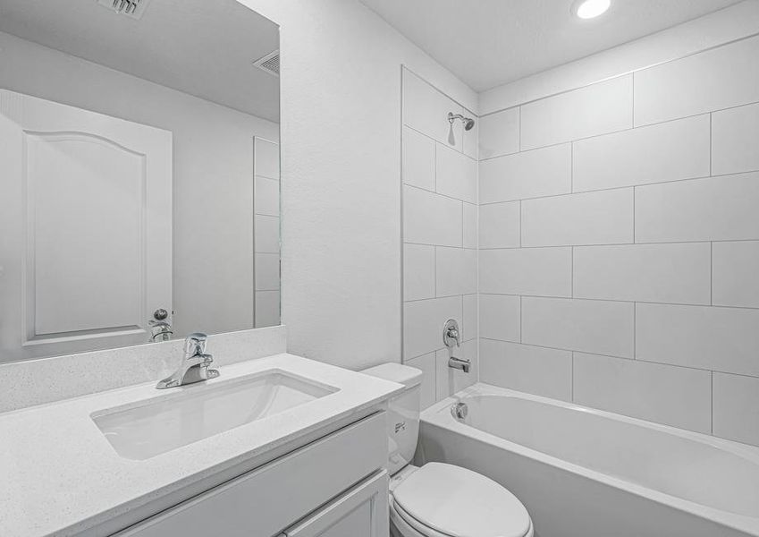 The spare bathroom has a large vanity and tub