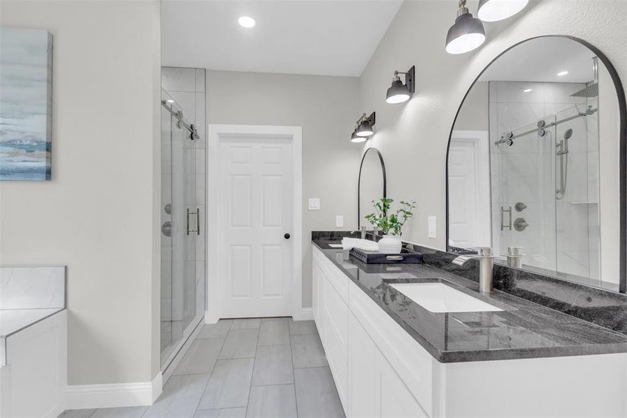 Full bath featuring double vanity, a shower stall, light tile patterned flooring, and recessed lighting