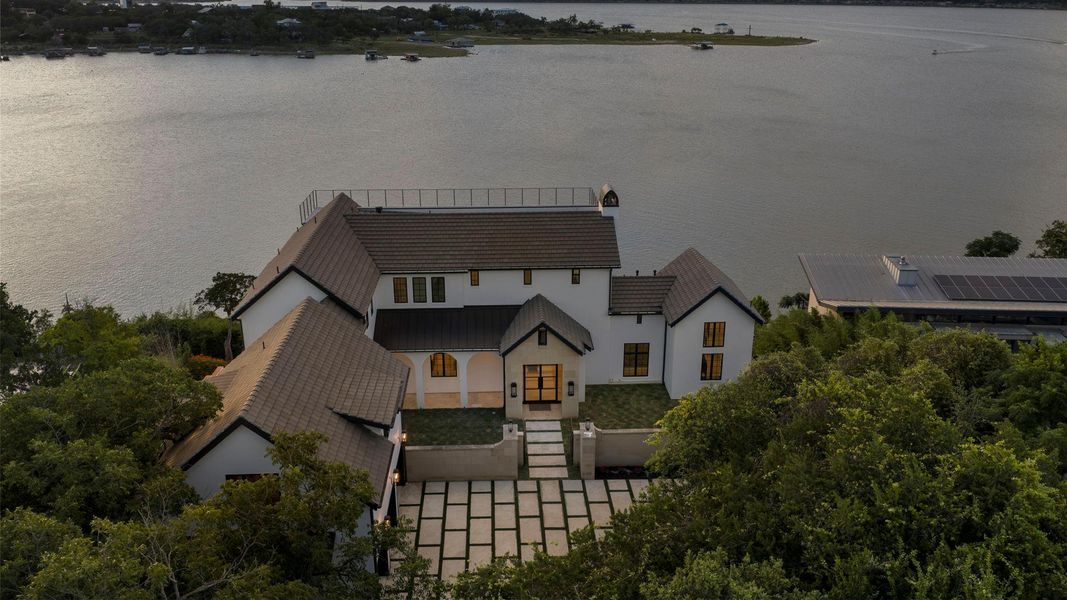 Perched above the serene lake, this expansive property offers a private oasis with a sophisticated design. Perched above the serene lake, this expansive property offers a private oasis with a sophisticated design.