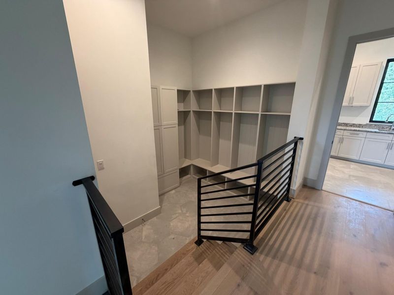 The mud room is at the entry from the garage and features built-in lockers and storage for the perfect drop zone before reaching the Elevator, utility, powder room, and main living spaces of the home.