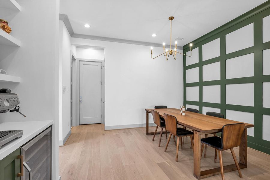 This full view of the formal dining area showcases its spacious layout, with the hallway leading to the garage visible at the opposite end of the room.