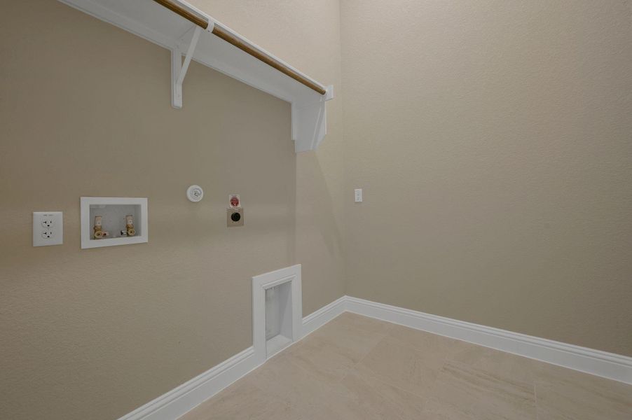 Washroom featuring hookup for a gas dryer, hookup for a washing machine, electric dryer hookup, and light tile patterned floors