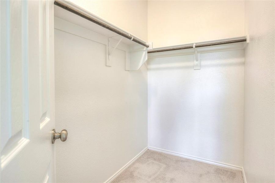 Walk in closet featuring light colored carpet Walk in closet featuring light colored carpet