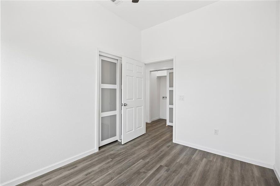 Unfurnished bedroom featuring a closet and dark hardwood / wood-style floors