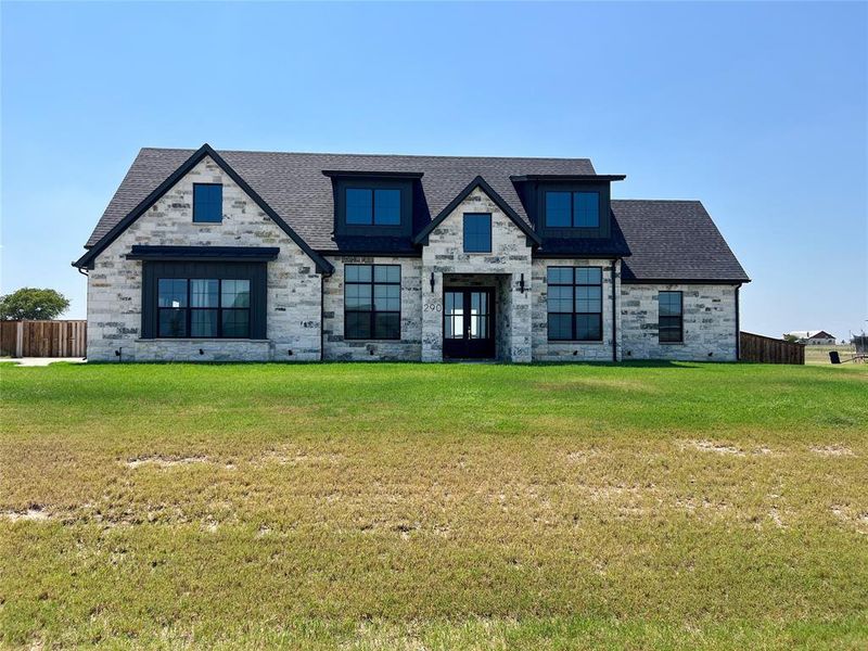 View of front of home with roof with shingles