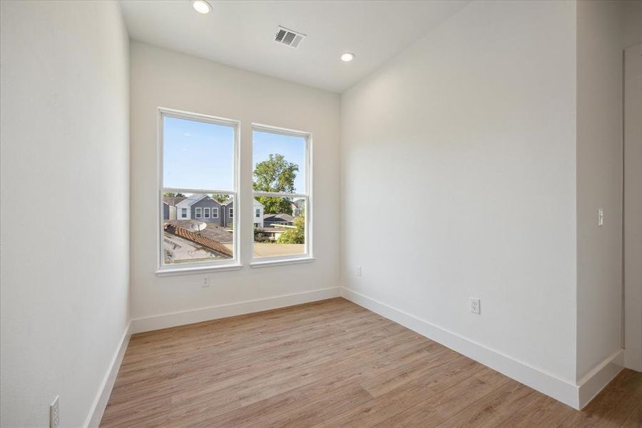 Secondary bedroom features recessed lighting, en-suite bathroom, and large window.