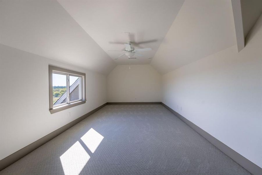 Additional living space featuring lofted ceiling, carpet flooring, and ceiling fan Additional living space featuring lofted ceiling, carpet flooring, and ceiling fan