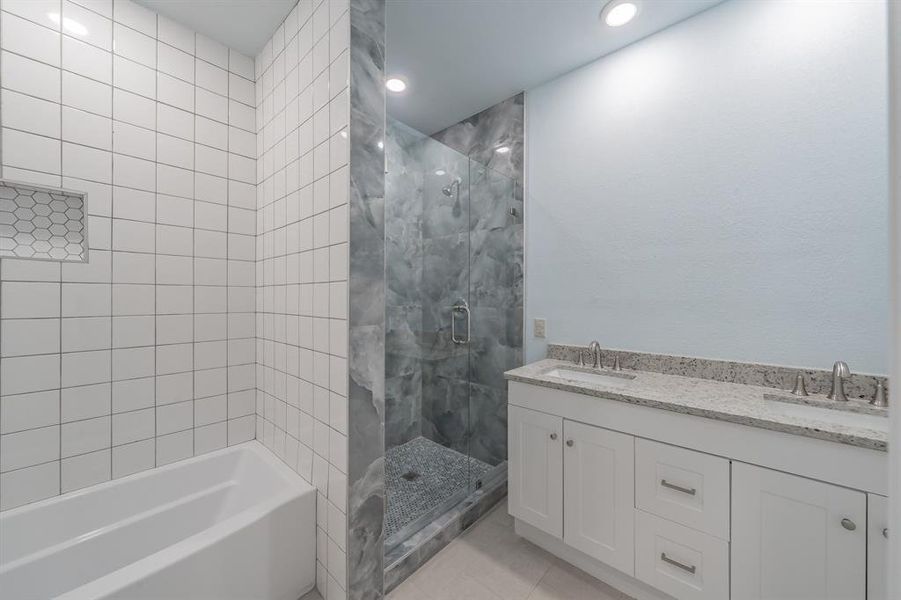Full bathroom with a stall shower, double vanity, a bath, tile patterned flooring, and recessed lighting Full bathroom with a stall shower, double vanity, a bath, tile patterned flooring, and recessed lighting
