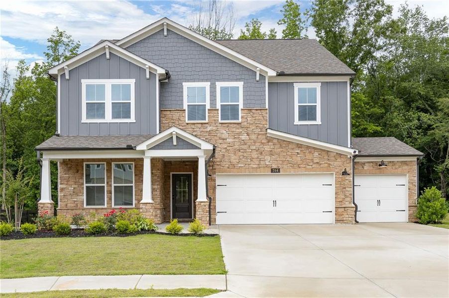 Front exterior of a new home in Hillside Manor, Powder Springs, GA, highlighting curb appeal (Image 2). Front exterior of a new home in Hillside Manor, Powder Springs, GA, highlighting curb appeal (Image 2).