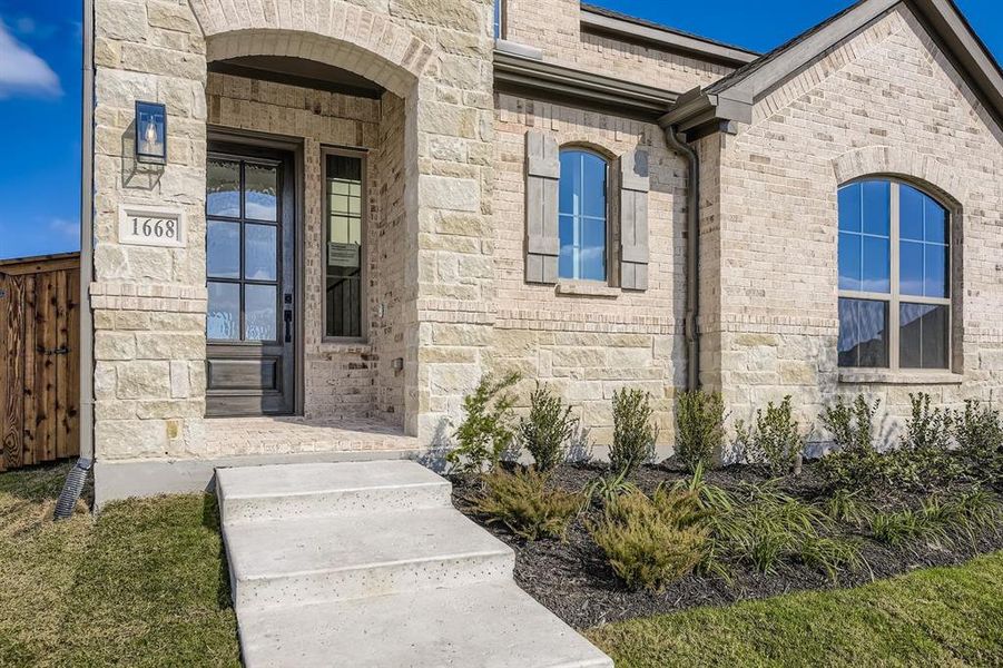 View of exterior entry featuring stone siding and brick siding