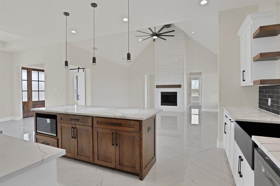 Kitchen with white cabinetry, ceiling fan, a barn door, and hanging light fixtures