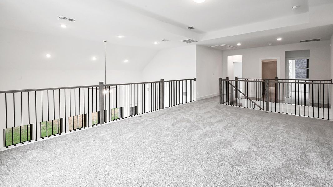 Empty room with carpet flooring, visible vents, vaulted ceiling, and recessed lighting