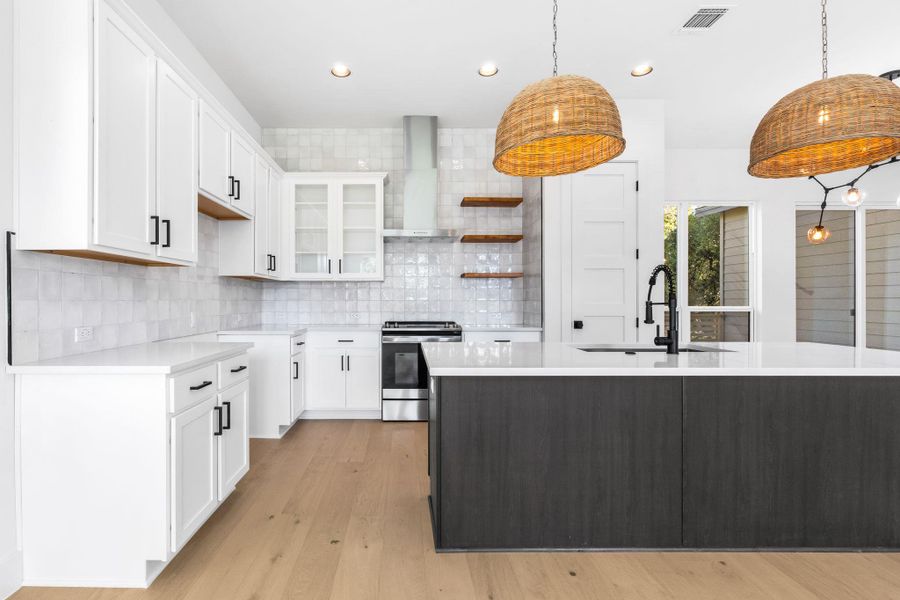 Kitchen featuring white cabinetry, open shelves, glass insert cabinets and timeless backsplash Kitchen featuring white cabinetry, open shelves, glass insert cabinets and timeless backsplash