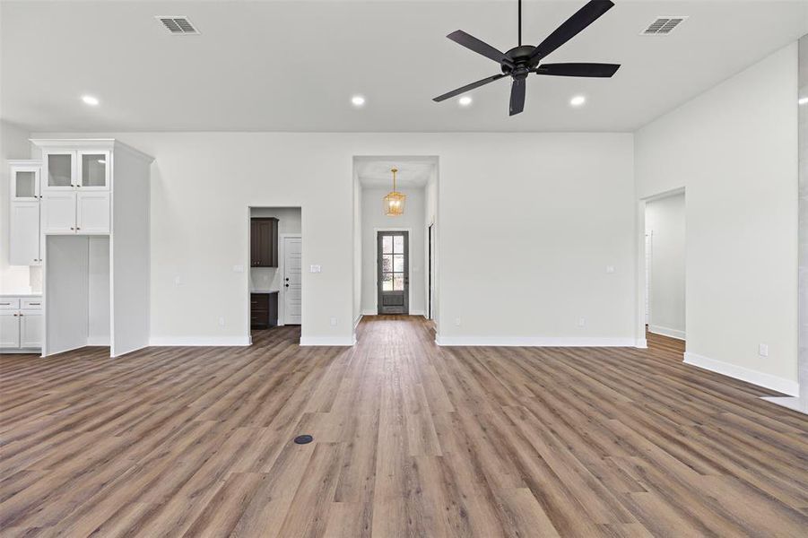 Unfurnished living room featuring recessed lighting, dark wood-style flooring, and a ceiling fan Unfurnished living room featuring recessed lighting, dark wood-style flooring, and a ceiling fan