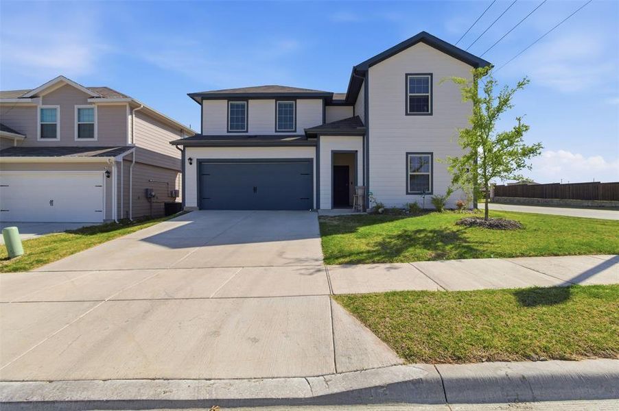 Traditional-style house with a garage and concrete driveway Traditional-style house with a garage and concrete driveway