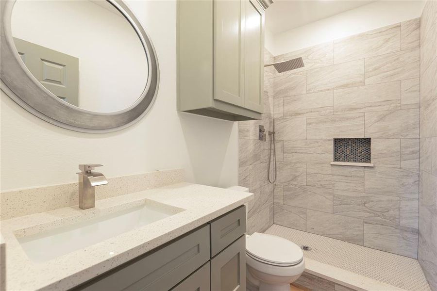Full bathroom with tiled shower and vanity