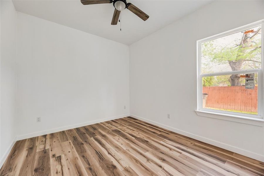 Empty room featuring light wood finished floors and ceiling fan