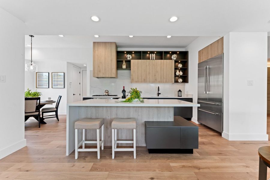 The designer kitchen wows with Thermador appliances, waterfall quartz island, and a clean-lined, split layout that works as beautifully as it looks.