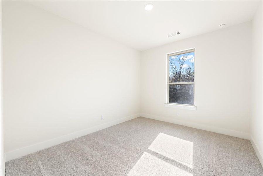 Spare room featuring carpet flooring and baseboards