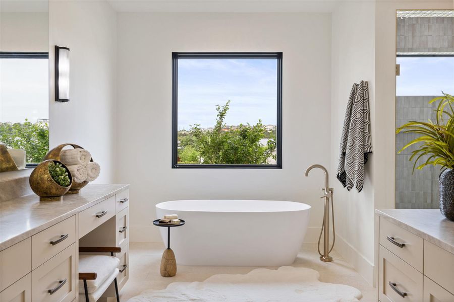 Full bathroom with tile patterned floors, vanity, a freestanding bath, and a healthy amount of sunlight Full bathroom with tile patterned floors, vanity, a freestanding bath, and a healthy amount of sunlight