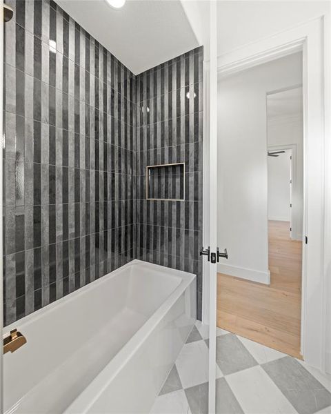 Bathroom with shower / washtub combination and baseboards