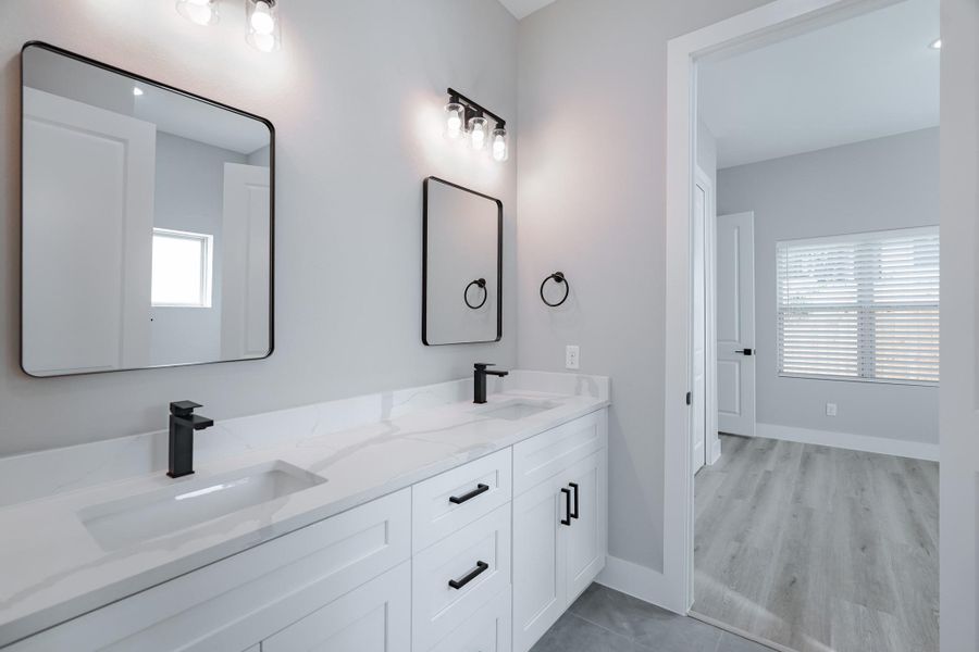 Secondary bathroom with double sinks and sleek walk-in shower