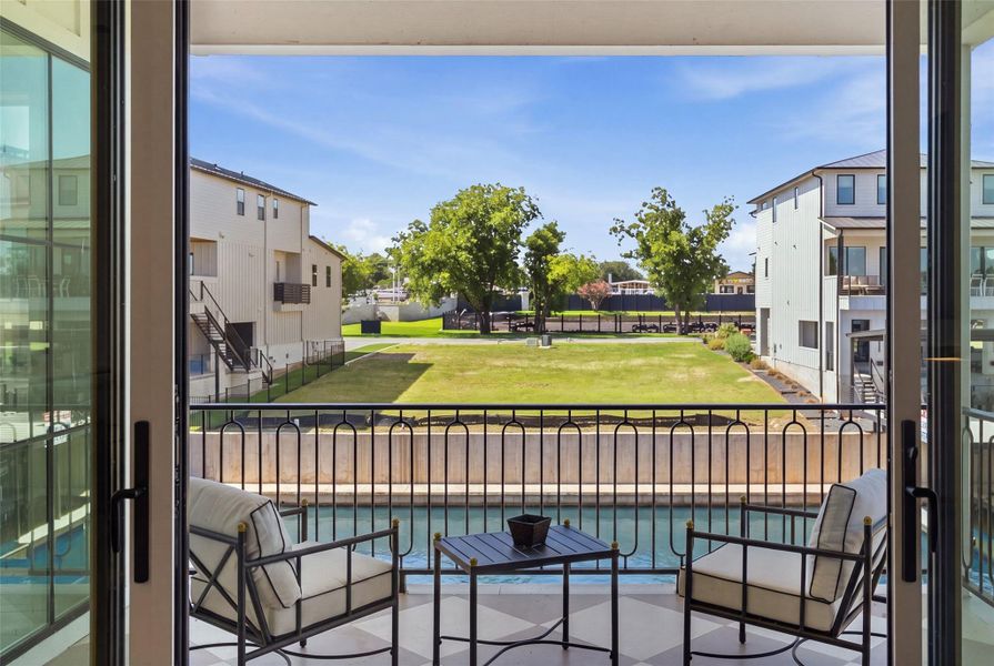 A tranquil water view from a private balcony overlooking a verdant lawn. A tranquil water view from a private balcony overlooking a verdant lawn.
